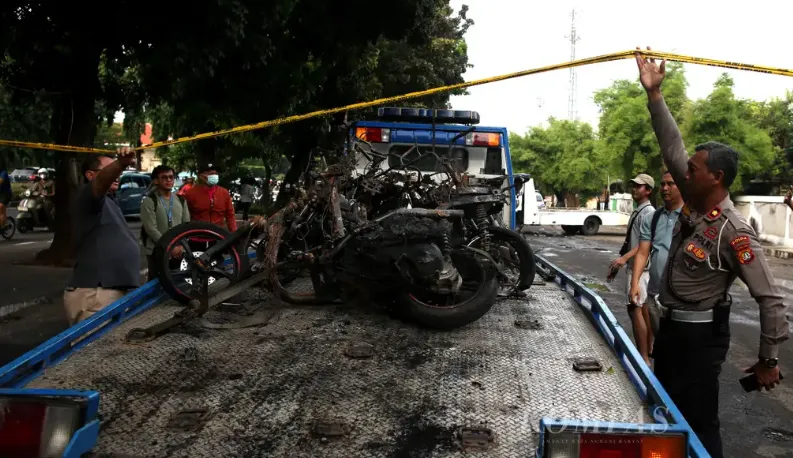Warga masyarakat dan petugas Kepolisian mengevakuasi bangkai sepeda motor dampak dari Insiden Kalibata. (Kompas) 
