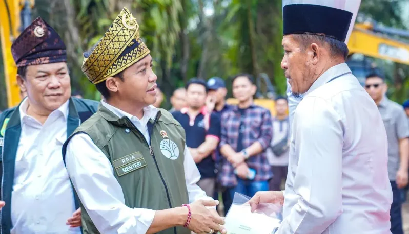 Menhut Raja Juli Antoni (kiri) dalam penyerahan SK bagi warga yang direlokasi dari TN Tesso Nilo di Desa Bagan Limau, Kabupaten Palalawan, Riau, Sabtu (20/12/2025). (Antara)