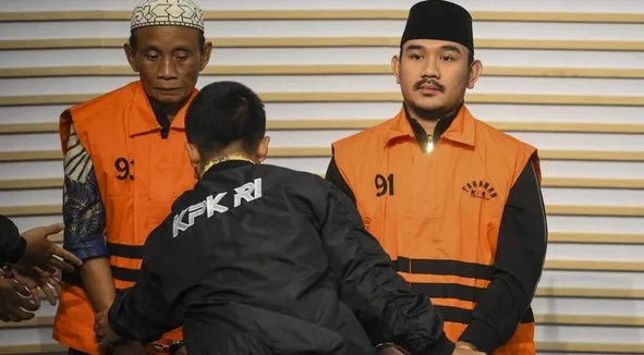 Ilustrasi: Bupati Bekasi Ade Kuswara Kunang (kanan) bersama ayahnya H. M. Kunang (kiri) saat konferensi pers penahanan usai terjaring OTT di Gedung Merah Putih KPK, Jakarta, Sabtu (20/12/2025).  (Antara via detik)