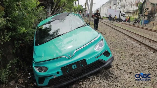 Foto: Kereta Krl melintas disamping taksi Green SM yang tertabrak KRL di perlintasan kereta Jalan Ampera, Bekasi, Selasa (28/4/2026). (CNBC Indonesia/Muhammad Sabki)