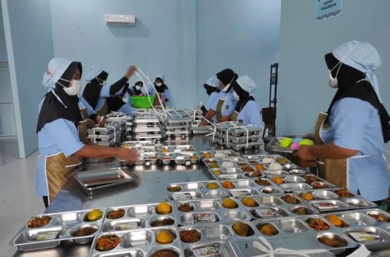 Proses pengemasan makan bergizi gratis di SPPG Rizky Barokah Desa Mlekang, Kecamatan Karanganyar, Kabupaten Demak, Senin (24/2/2025).(KOMPAS.COM/NUR ZAIDI)