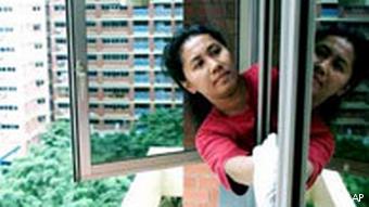 Pembantu Indonesia bersihkan jendela flat tinggi di Singapura (foto: dw)