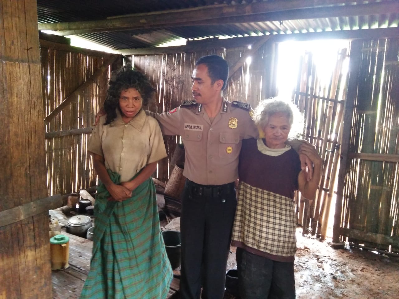 Bripka Arsilinus Lentar, Bhabinkamtibmas Polsek Lamba Leda, Manggarai Timur mengunjungi gubuk reot milik Paulina Lawus di Desa Compang Deru, Manggarai Timur, NTT (Ist/Law-Justce.co)